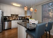 Thumbnail 1 of 45 - a kitchen with white cabinets and a granite counter top