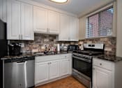 Thumbnail 2 of 45 - a kitchen with white cabinets and stainless steel appliances