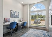 Thumbnail 19 of 36 - a office with a large window and a desk with two chairs