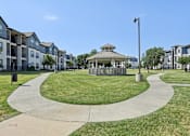 Thumbnail 28 of 36 - a park with a gazebo in the middle of an apartment complex