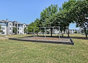 Thumbnail 30 of 36 - a park with a swing set and trees in front of an apartment building