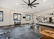 Thumbnail 29 of 39 - a home gym with a gym flooring and a ceiling fan