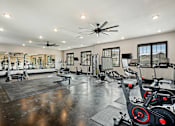 Thumbnail 31 of 39 - a spacious fitness room with cardio equipment and windows