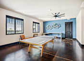 Thumbnail 28 of 39 - a game room with a ping pong table and chairs