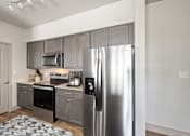 Thumbnail 9 of 39 - a kitchen with gray cabinets and stainless steel appliances