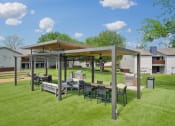 Thumbnail 26 of 41 - a patio with a table and chairs under a canopy