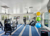 Thumbnail 36 of 41 - a gym with treadmills and other exercise equipment in a room with windows