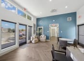 Thumbnail 22 of 41 - a living room with blue walls and a large window and a table and chairs