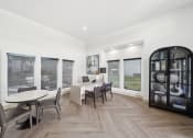 Thumbnail 20 of 41 - a dining room with a table and chairs and large windows