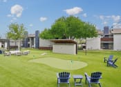 Thumbnail 34 of 41 - a yard with lawn chairs and a mini golf course