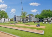 Thumbnail 31 of 41 - a park with a playground and picnic tables in front of a building