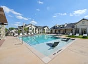 Thumbnail 35 of 38 - the preserve at ballantyne commons pool with lounge chairs and apartment buildings