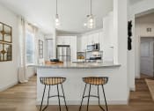 Thumbnail 3 of 38 - an open kitchen with bar stools in front of a granite counter top