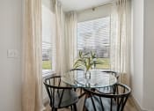 Thumbnail 7 of 38 - a dining room with a glass table and three chairs in front of a window