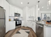 Thumbnail 4 of 38 - a kitchen with white cabinets and stainless steel appliances