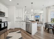 Thumbnail 6 of 38 - an open kitchen and living room with an island and a dining table