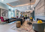Thumbnail 31 of 55 - A modern clubroom with a grey sofa and a fireplace.
