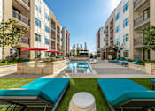 Thumbnail 25 of 55 - A swimming pool surrounded by a grassy area and lounge chairs.