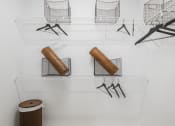 Thumbnail 16 of 35 - a room with wire baskets on the wall and a wooden stool on the floor