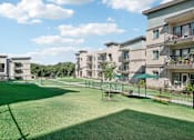 Thumbnail 21 of 21 - a large green lawn in front of an apartment building