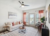 Thumbnail 1 of 21 - a living room with a couch and a ceiling fan