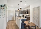 Thumbnail 5 of 21 - an open kitchen and dining area with a wood floor and white walls