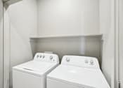 Thumbnail 6 of 21 - the laundry room of a home with two washes and a dryer