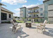 Thumbnail 16 of 21 - a patio with chairs and tables in front of an apartment building