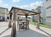 Thumbnail 20 of 21 - a patio with a table and chairs under a gazebo