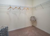 Thumbnail 20 of 50 - a walk in closet with white walls and carpet