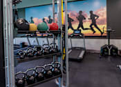 Thumbnail 34 of 50 - a gym with weights and a mural of runners on the wall