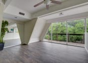 Thumbnail 13 of 23 - an empty living room with a ceiling fan and large windows