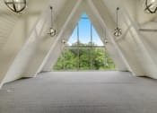 Thumbnail 12 of 23 - an attic room with large windows and a view of trees