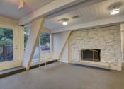 Thumbnail 14 of 23 - a living room with a stone fireplace and a window