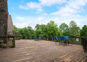 Thumbnail 17 of 23 - a deck with a tree and chairs on it