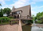 Thumbnail 20 of 23 - a house on the water with a wooden deck