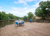 Thumbnail 16 of 23 - a deck with a table and chairs on it overlooking a body of water