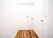 Thumbnail 15 of 47 - a room with white walls and wood floors and a white door