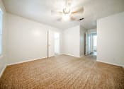 Thumbnail 18 of 47 - an empty living room with white walls and a ceiling fan