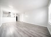 Thumbnail 23 of 47 - an empty living room with white walls and wood floors