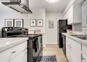 Thumbnail 9 of 30 - a kitchen with white cabinets and black appliances