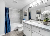 Thumbnail 16 of 30 - a white bathroom with a blue shower curtain and a toilet