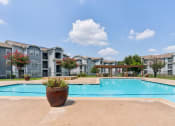 Thumbnail 6 of 24 - a large swimming pool with apartments in the background