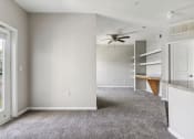 Thumbnail 18 of 24 - an empty living room with carpet and a ceiling fan