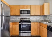 Thumbnail 24 of 24 - a kitchen with wooden cabinets and stainless steel appliances