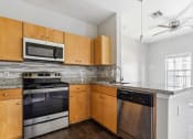 Thumbnail 23 of 24 - an empty kitchen with wooden cabinets and stainless steel appliances