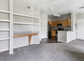 Thumbnail 16 of 24 - an empty living room with white shelves and a kitchen