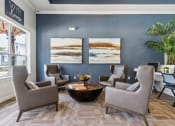 Thumbnail 13 of 24 - a living room with blue walls and chairs and a table