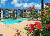 Thumbnail 8 of 24 - a swimming pool with an apartment building in the background