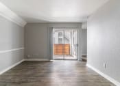 Thumbnail 29 of 30 - an empty living room with a sliding glass door to a patio